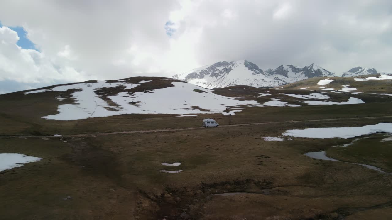 Luftoptagelse, der panorerer ud fra en autocamper og afslører et åbent plateau, Montenegro