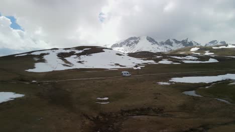 Aerial-panning-out-from-camper-van-revealing-open-plateau,-Montenegro