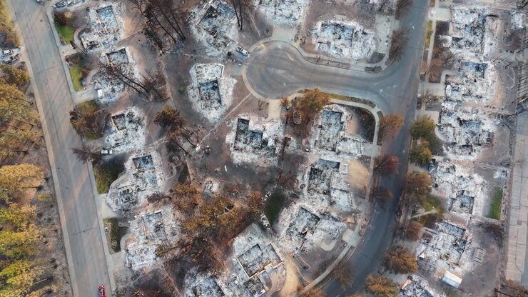 Danni dell'incendio Spokane Old Trails mostrati in un sorvolo dall'alto su proprietà bruciate, alberi anneriti e diffusa distruzione residenziale dopo l'incendio boschivo del 2026