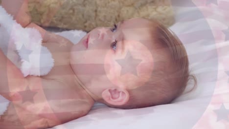 Animation-of-flag-of-usa-waving-over-caucasian-infant