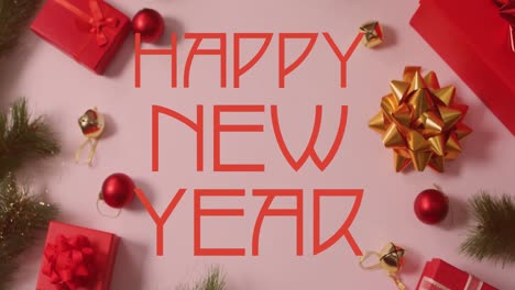 Animation-of-happy-new-year-text-banner-over-christmas-decorations-and-gifts-on-pink-background