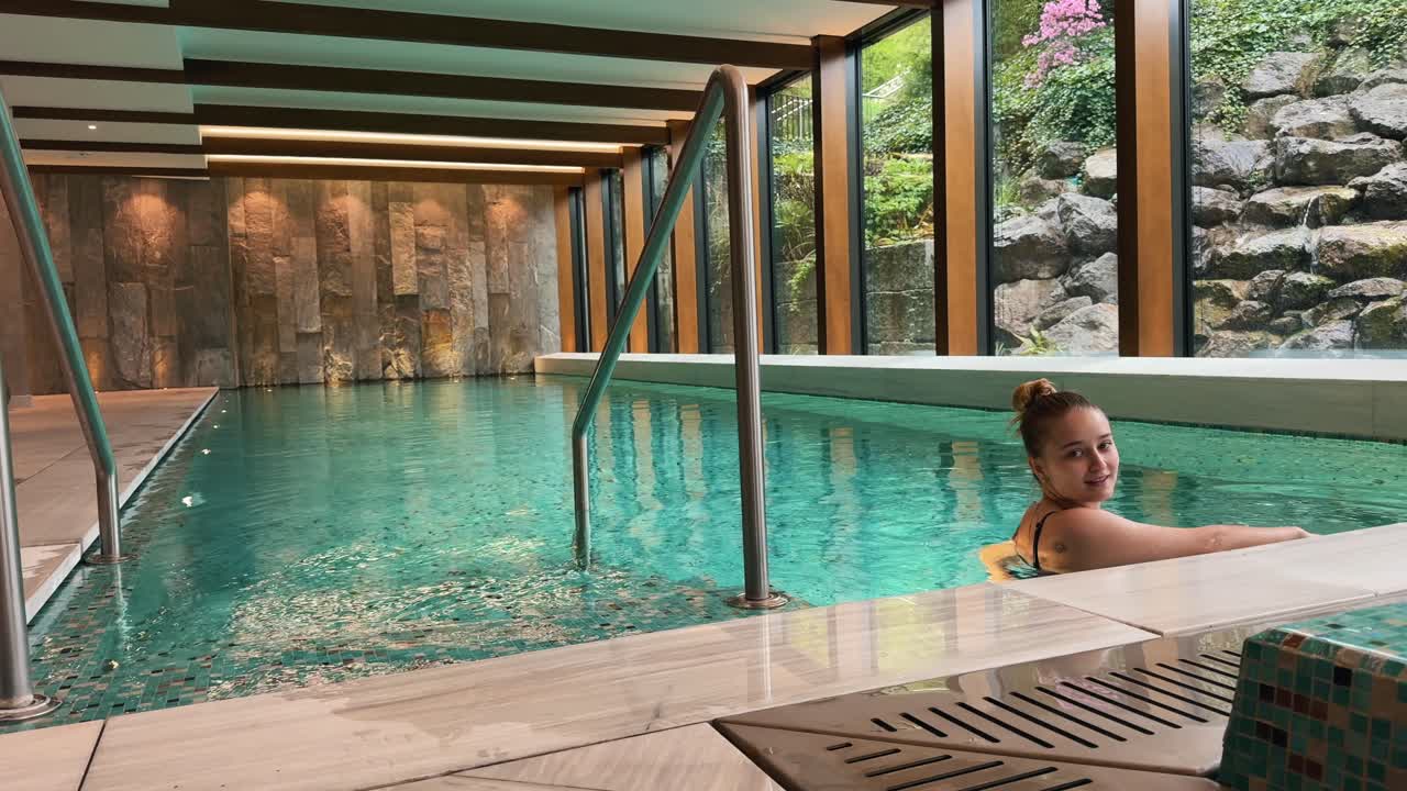 woman looking around in a luxury hotel pool in Zurich, Switzerland