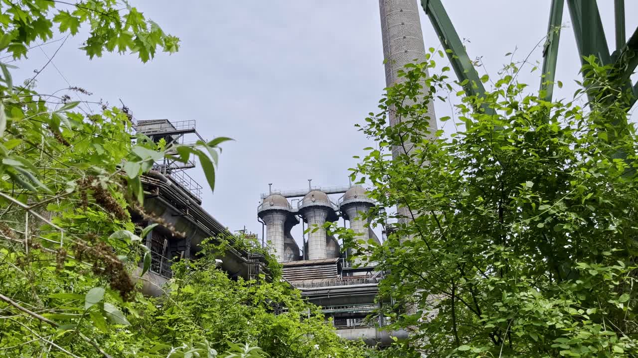 독일의 두스부르크 노르드 풍경 공원의 오래된 강철 고분 가루가 자연 사이에서 자라고 있습니다.