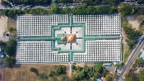 a stunning aerial view of kuthodaw pagoda in mandalay, myanmar, surrounded by 729 white shrines that house the world's largest book, with a golden stupa at the center of the symmetrical layout