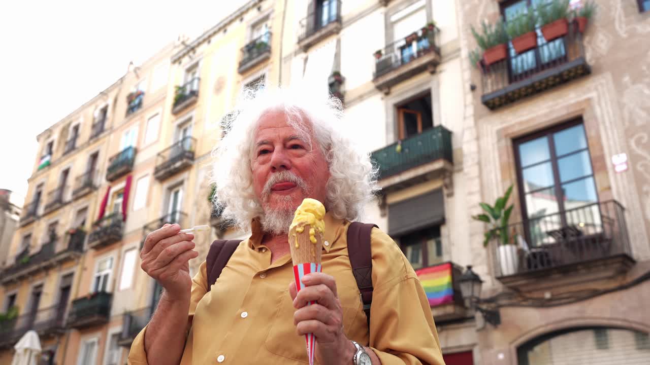 Uomo anziano felice che mangia un gelato per strada in città.