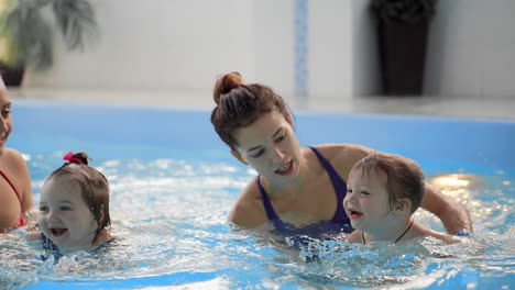 Gruppe-Von-Müttern-Mit-Ihren-Kleinen-Kindern-Beim-Kleinkindschwimmkurs