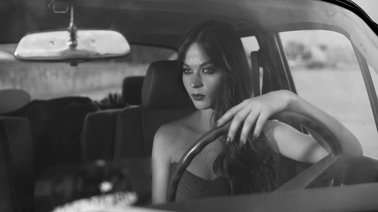 una mujer conduciendo un coche de época.