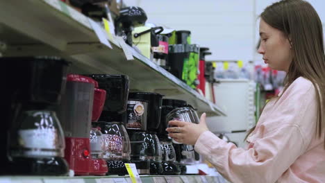 woman shopping for coffee makers in a grocery store