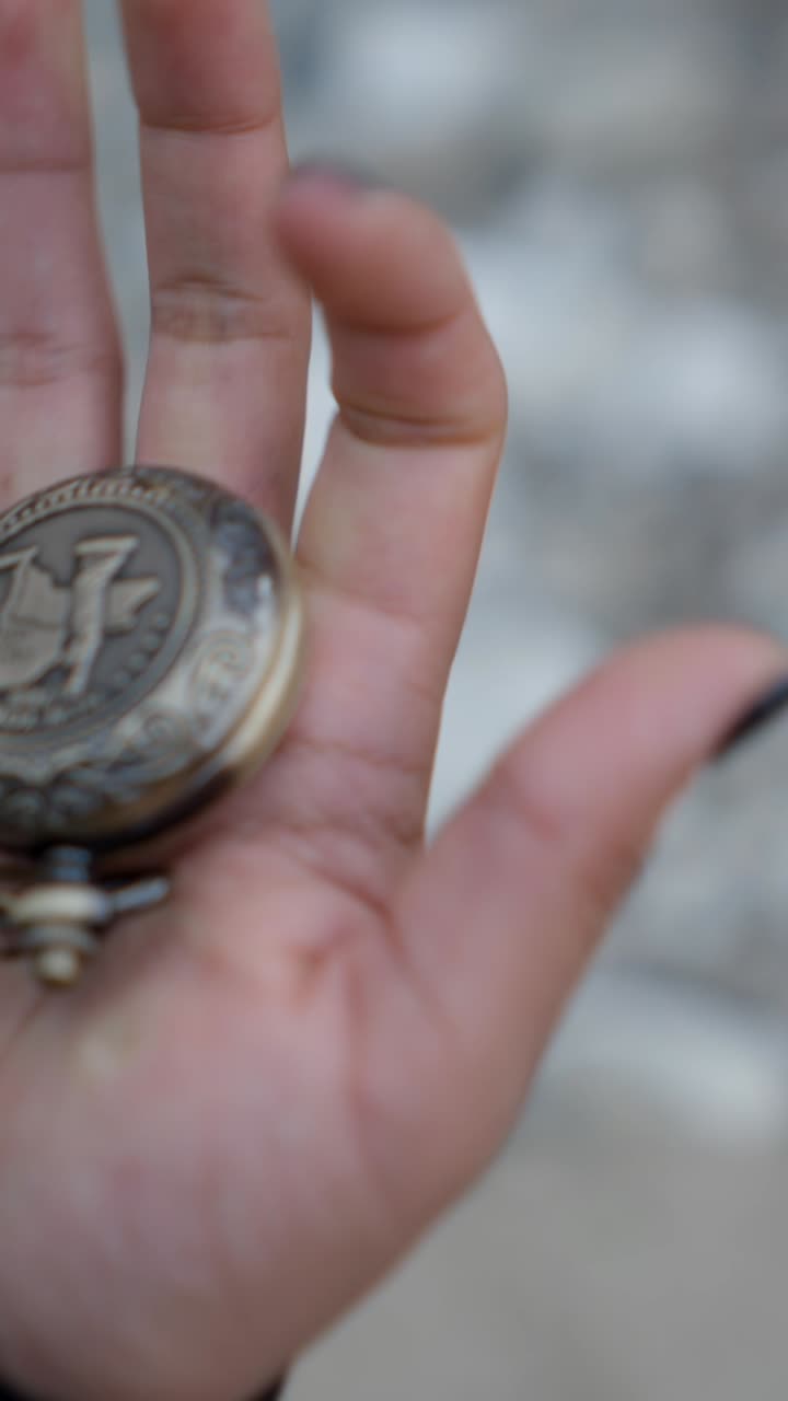 Hand holding an antique pocket compass