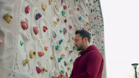 Man-Climber-Warming-up-Hands-Wrist-Before-Exercising-on-Climbing-Wall-Outdoors---slow-motion