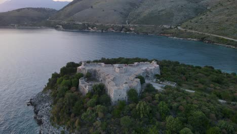 vista a vista de aves de la fortaleza de ali pasha construida en una hermosa isla en la bahía de porto palermo a lo largo de un vasto mar azul