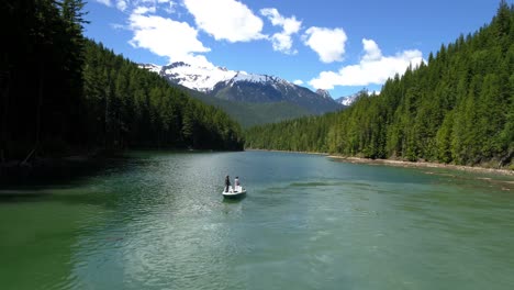 Two-men-fishing-in-the-river-while-sailing-in-the-boat-on-a-sunny-day-4K-4k