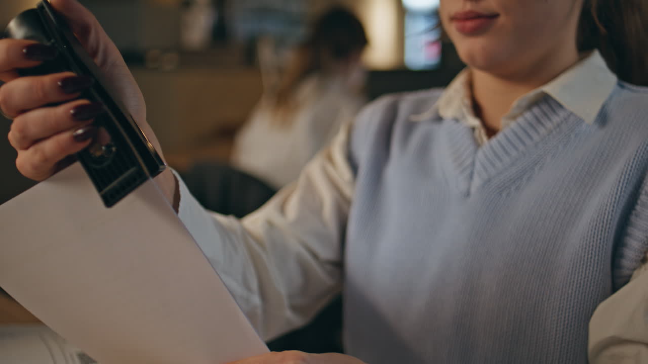 Closeup secretary doing paperwork at late coworking. Busy lady staple documents