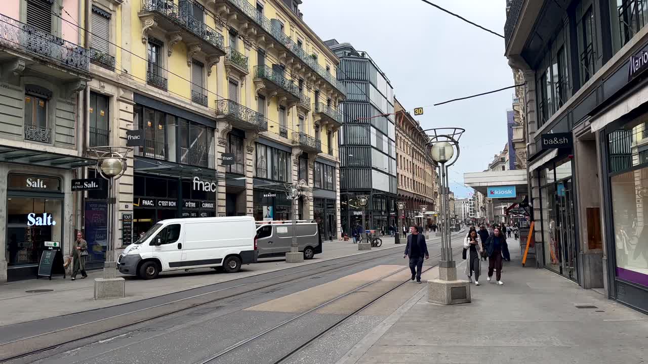 People Walking on a City Street with Tram Tracks