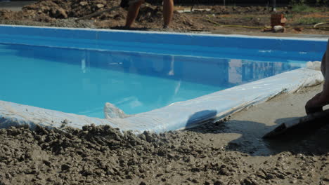 concrete flows down the gutters where workers make paving 1