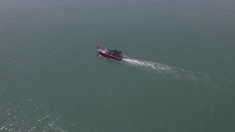 Aerial-drone-shot-of-a-lonely-fishing-ship-in-the-middle-of-the-sea