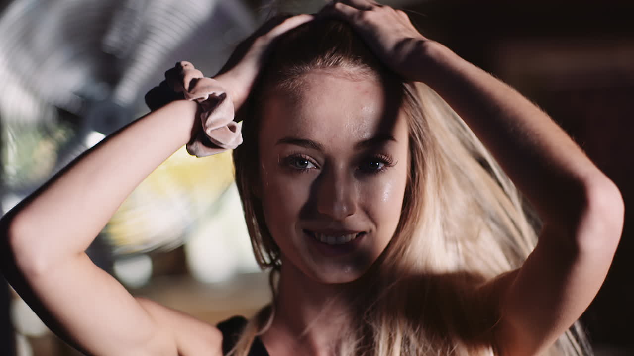 cámara lenta de atleta femenina atractiva sonriente moviendo las manos a través del cabello en el club de salud 3