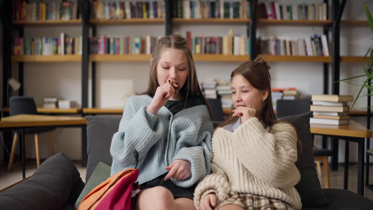 Teenage Girls Enjoying a Snack in the Library