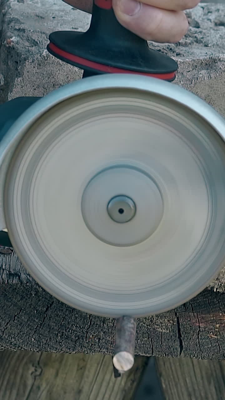 close view powerful hand circular saw cuts piece of metal rod fixed with stone on rough wooden table