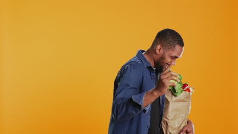 male person playing around with a green apple in studio