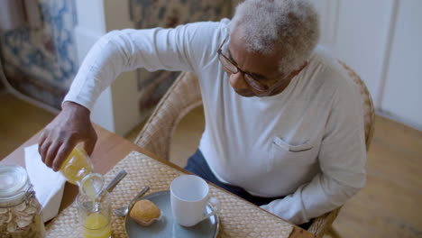 black elderly man enjoying breakfast at home.