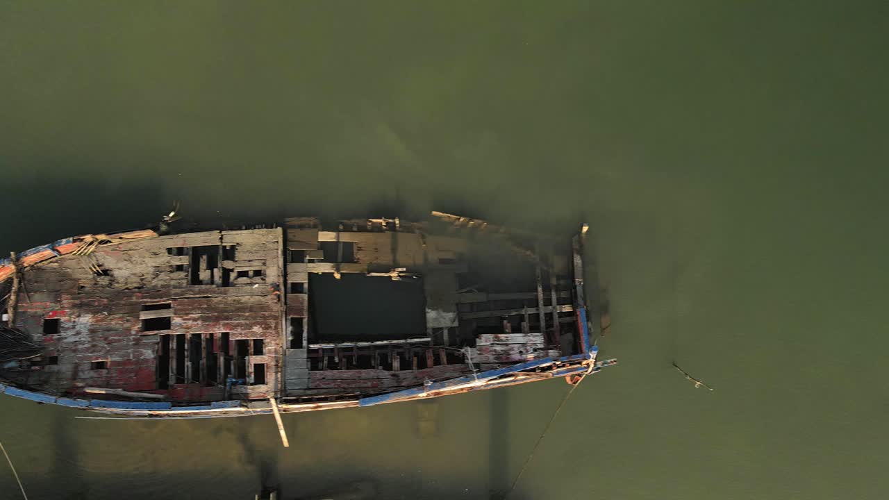 Fast top down aerial shot above an old shipwreck along the coast of Koh Chang, Thailand.