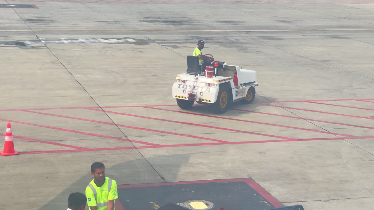 View from window of ground support vehicles handling operations after arrival of an airplane in Pakistan.