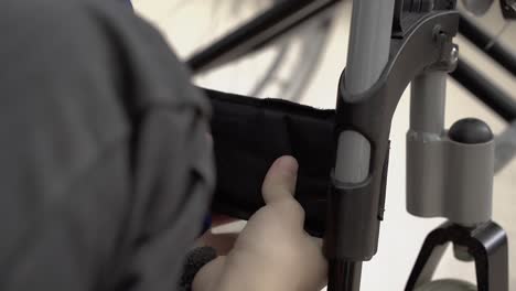 young guy fixes the leg fastener to the wheelchair