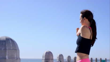 athletic woman stretching on promenade before running