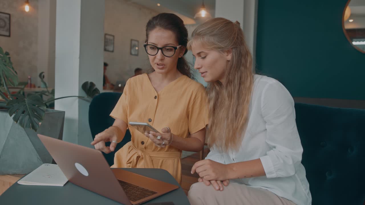 Two Women Collaborating in a Cafe