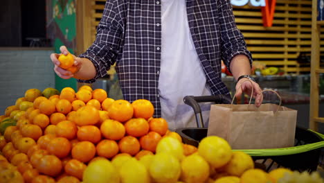 man shopping for citrus fruits in a grocery store