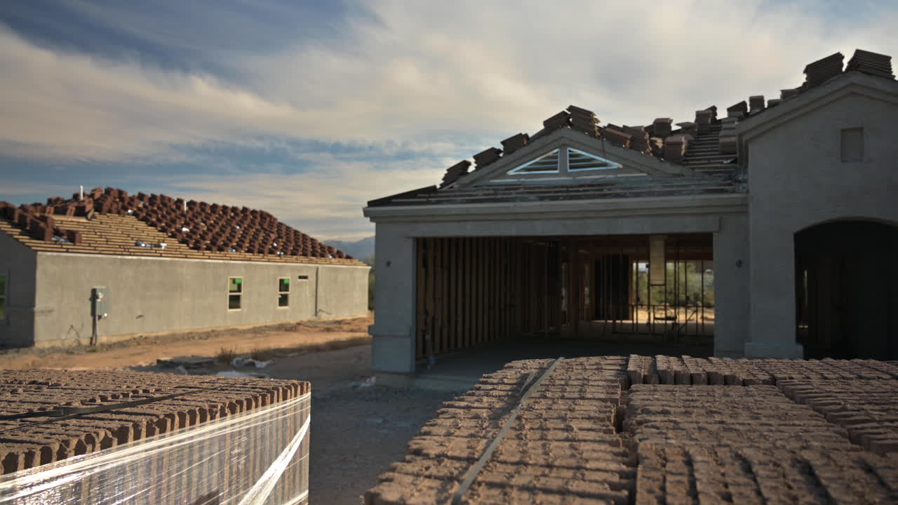 New home construction in residential area with roof tiles in foreground