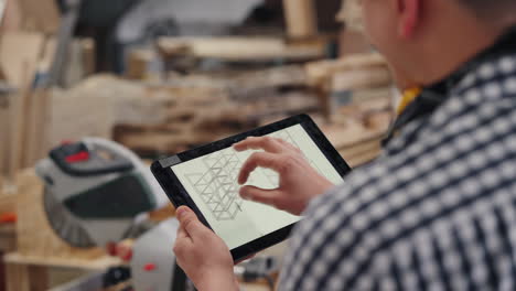 woodworker reviewing digital design on tablet