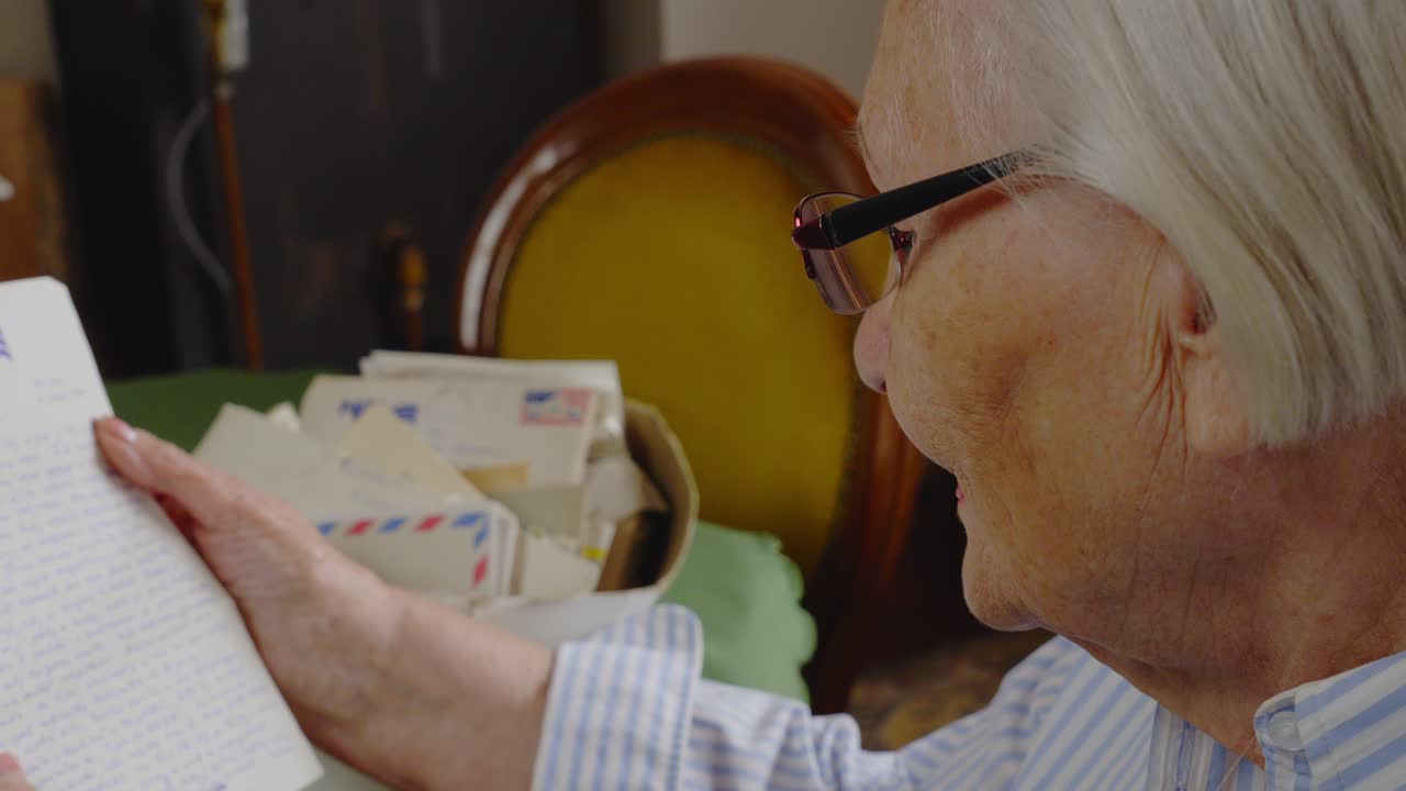 Elderly lady muses and reminisces reading old emotive family letters