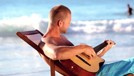 Mann-Spielt-Gitarre-Am-Strand