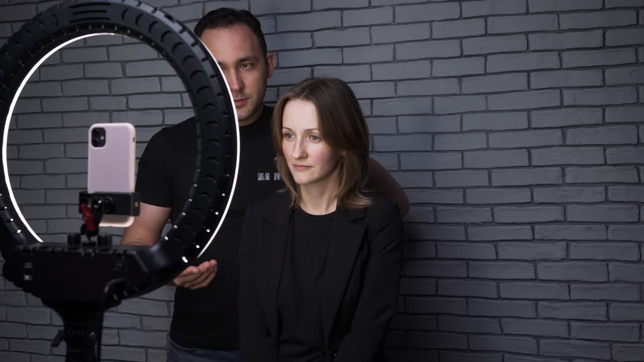 fotografía de una pareja de bloggers con una lámpara de anillo en el fondo de la pared de ladrillo