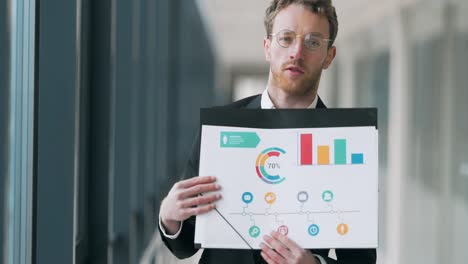 Handsome-nice-man-makes-a-presentation-on-infographics