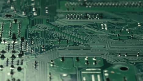 extreme close up motion view green circuit board, semiconductor pins, rack focus