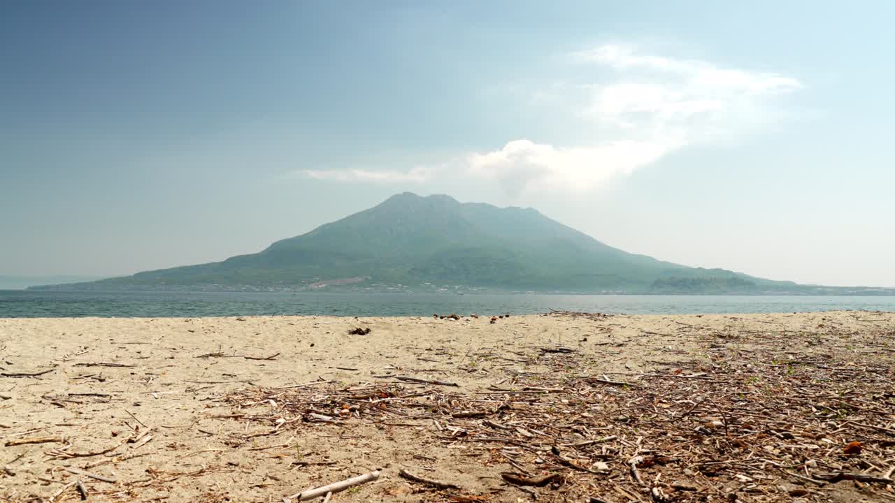 사쿠라지마는 모래 해변 너머로 퍼져 있습니다.