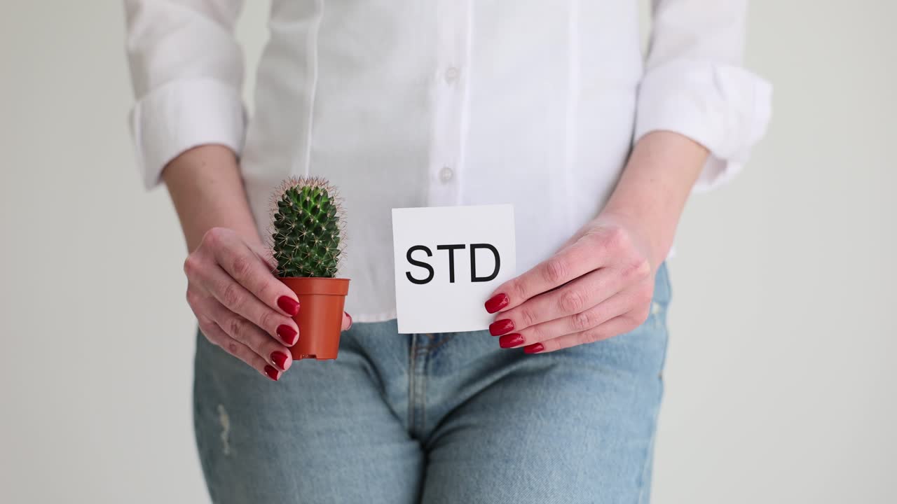 Kvinde holder kaktus i potte og papir med 'std'-inskription.