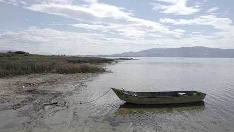 Video-Mit-Einer-Drohne-Auf-Dem-Skadarsee-In-Albanien,-Auf-Einem-Alten-Holzboot-Im-Vordergrund,-Das-In-Verschiedenen-Ebenen-Auf-Wasserhöhe-übertroffen-Wird