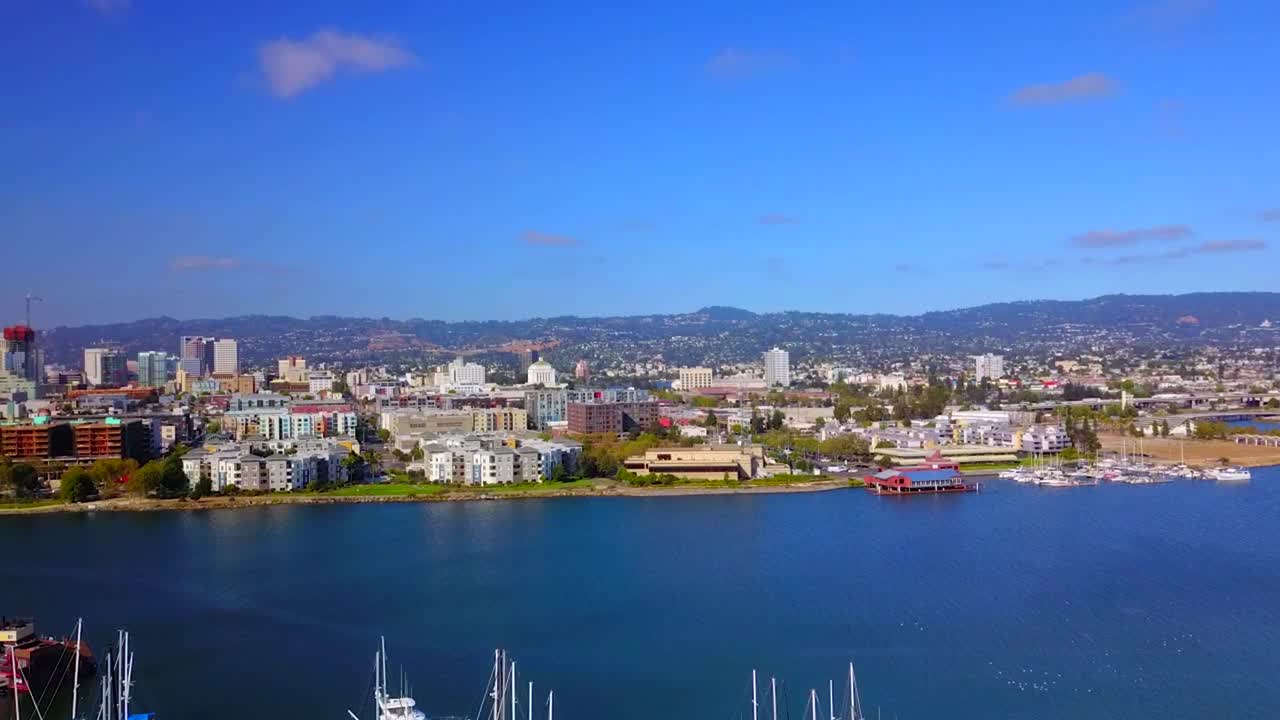 Beautiful sailboats and wonderful color in a marina with a large city in the background.
