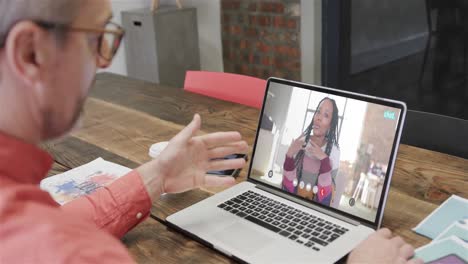 hombre de negocios caucásico en una llamada de video portátil con una colega afroamericana en la pantalla