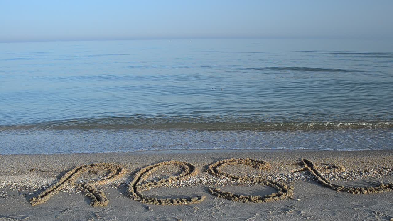 Inscription rest on sand, the beach. Inscription on sand, the beach