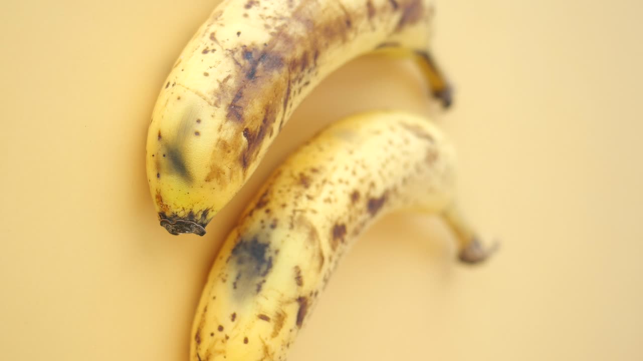Two overripe bananas on a light background