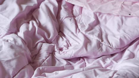 pink comforter on a bed