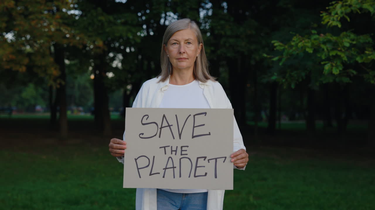 Woman Holding "Save The Planet" Sign in Park