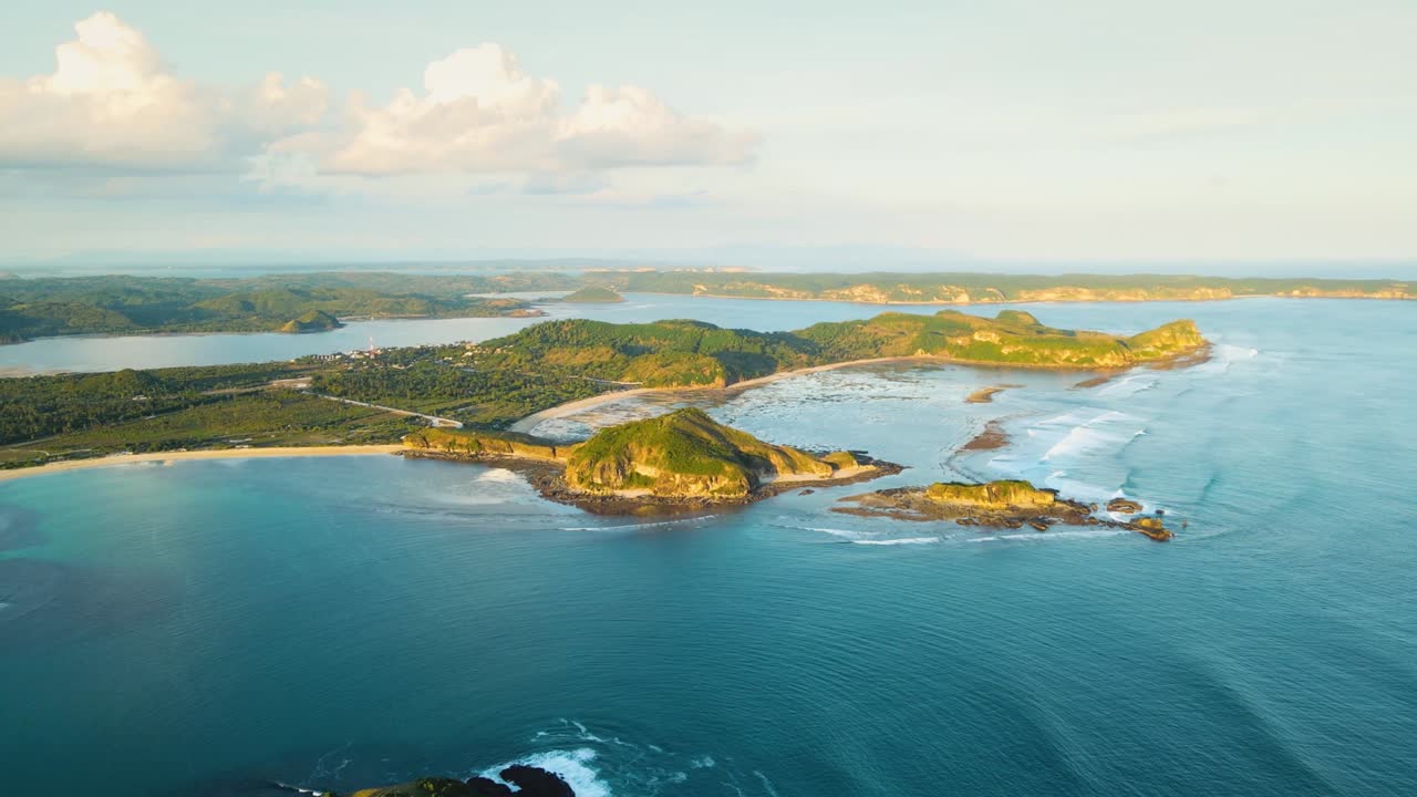 tomado en órbita aérea sobre la isla de lombok con las famosas colinas de bukit merese y playas de arena con olas que se estrellan desde el océano. lombok, indonesia.