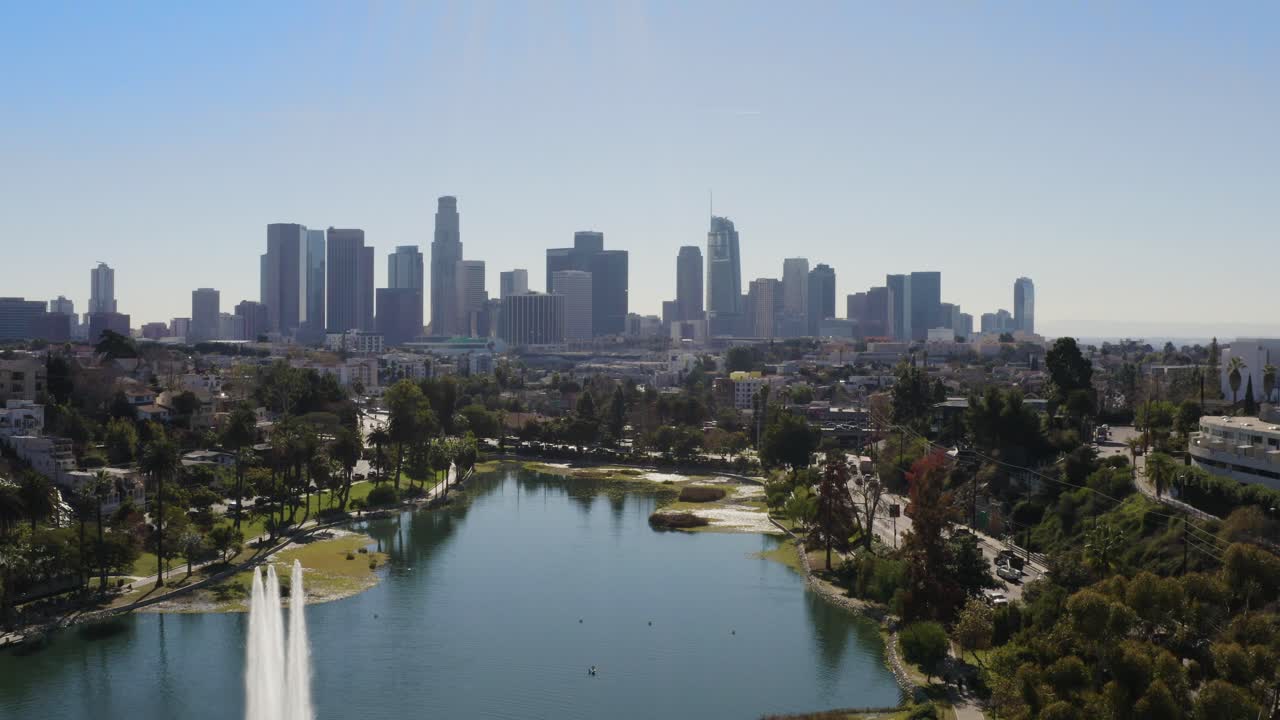 Amazing aerial pedestal of lake fountain with downtown buildings on a warm sunny day