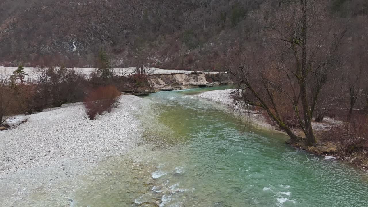 Julian Alpleri'nde kış mevsiminde, Slovenya'daki Triglav Milli Parkı'nda Kamnje yakınlarındaki karlı ormanların ve engebeli Alp arazisinin arasından kıvrılarak akan Sava Bohinjka Nehri'nin panoramik bir havadan görünümü.